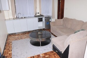 Deluxe-lejlighed - udsigt til have | Opholdsområde | 32-tommers smart-tv med digitale kanaler