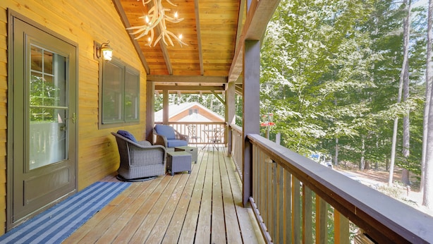 A wooden deck with a railing, a covered porch, and a view of trees. - Game Room + Lake Access: Wooded Retreat in Jay (Jay)