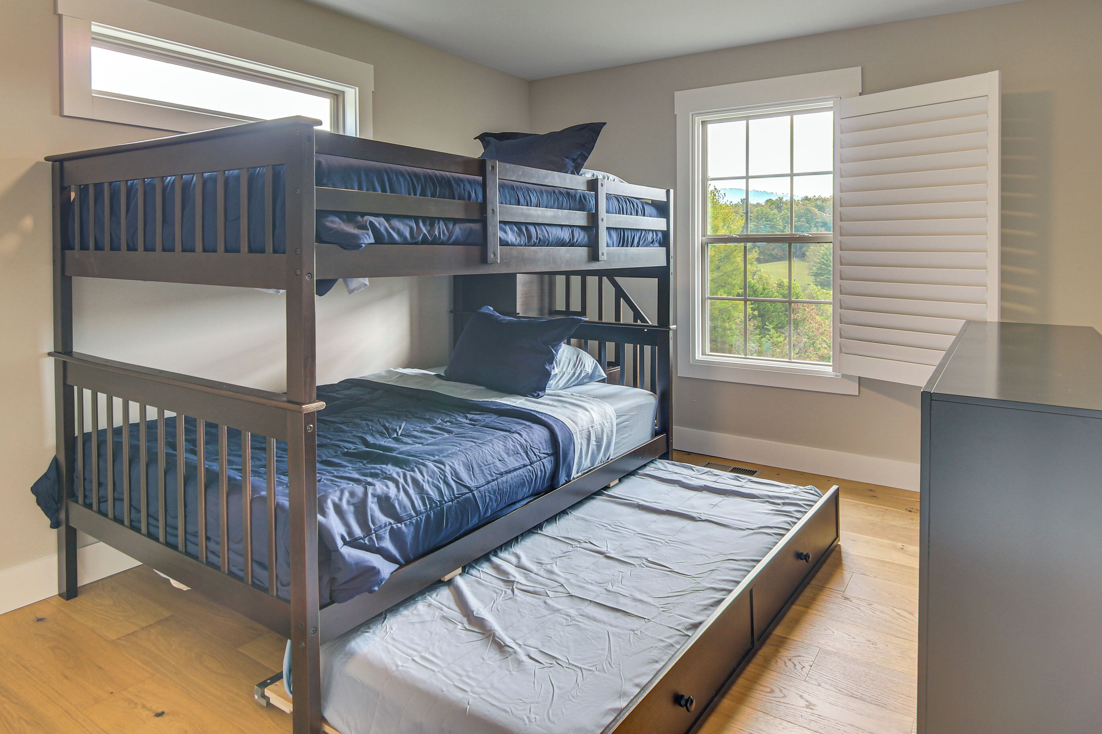 Una cama litera con una cama inferior, un colchón, almohadas y estructura de madera.