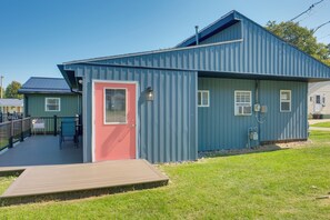 A blue building with a red door, a covered deck, and a small outdoor seating area. - 'blue Heron' Walk to Kelso Beach! Pet-friendly Gem (Erie)