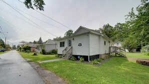 A single-story house with a front porch, a small front yard, and a street view. - 'wishin & Fishin' Walkable Erie Home By the Beach! (Erie)
