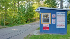 A small blue building with multiple signs indicating rules and fees for parking and property use. - 'wishin & Fishin' Walkable Erie Home By the Beach! (Erie)