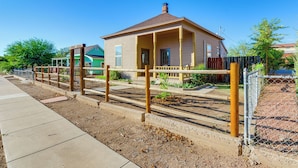 A two-story house with a porch, a fenced garden, and a sidewalk. - Walkable Location, Fenced Yard: Wickenburg Home! (Wickenburg)