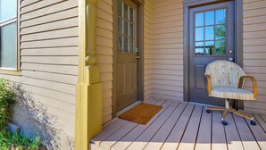 A wooden porch with a door and a chair. - Walkable Location, Fenced Yard: Wickenburg Home! (Wickenburg)