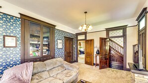 Ein Wohnzimmer mit einem beigefarbenen Sofa, einem Holztisch und einem Bücherregal.