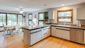 A modern kitchen with a central island, built-in appliances, and large windows. - 4 Mi to Dtwn Loveland: Private Retreat w/ Decks (Loveland)