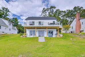 Une maison à deux étages avec un balcon, un porche à l’avant et une cheminée.