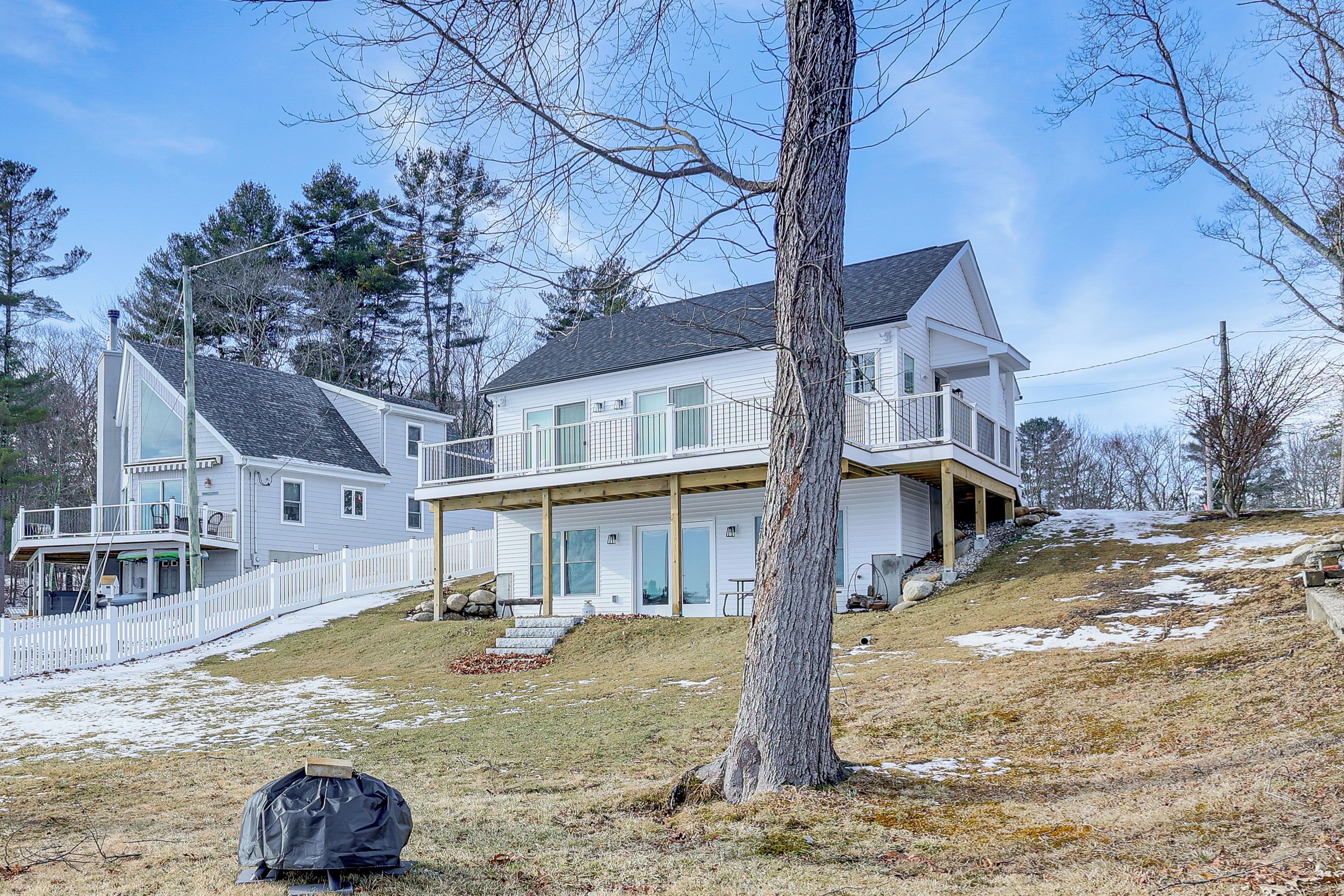 A two-story house with a covered porch and a fenced yard.