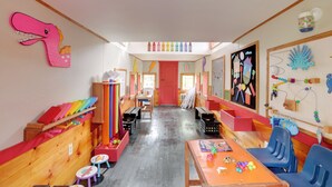 A brightly colored children's playroom with wooden furniture, colorful decorations, and educational materials. - 'the Ringmaster,' Converted Railcar in Dubois! (DuBois)