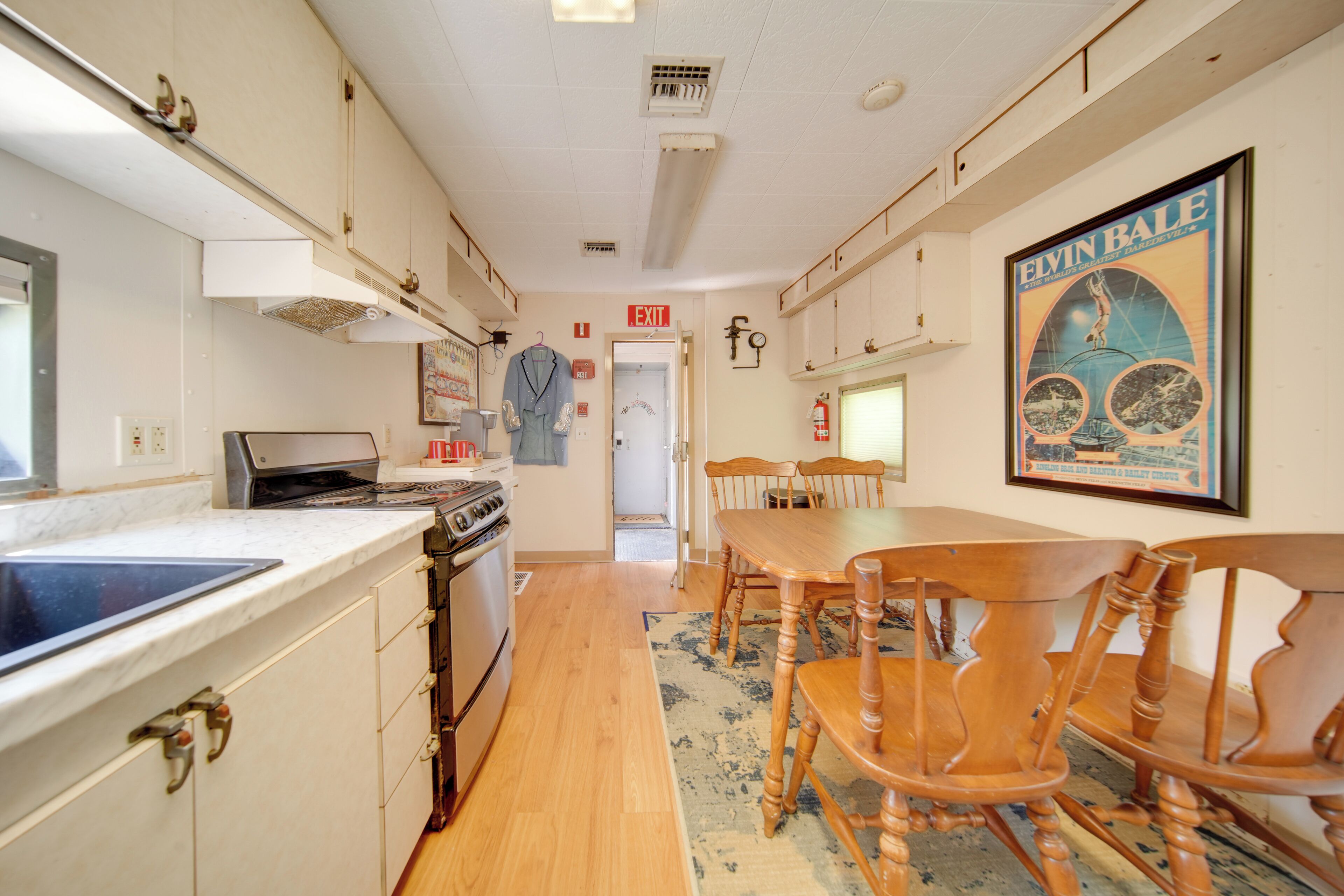 Une cuisine équipée d’un fourneau, de placards et d’un coin repas avec une table et des chaises.