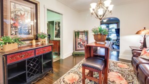 A well-lit living room with a chandelier, a wooden coffee table, a sofa, and a fireplace. - Walk to UT Southern & Dtwn Pulaski: Historic Home (Pulaski)