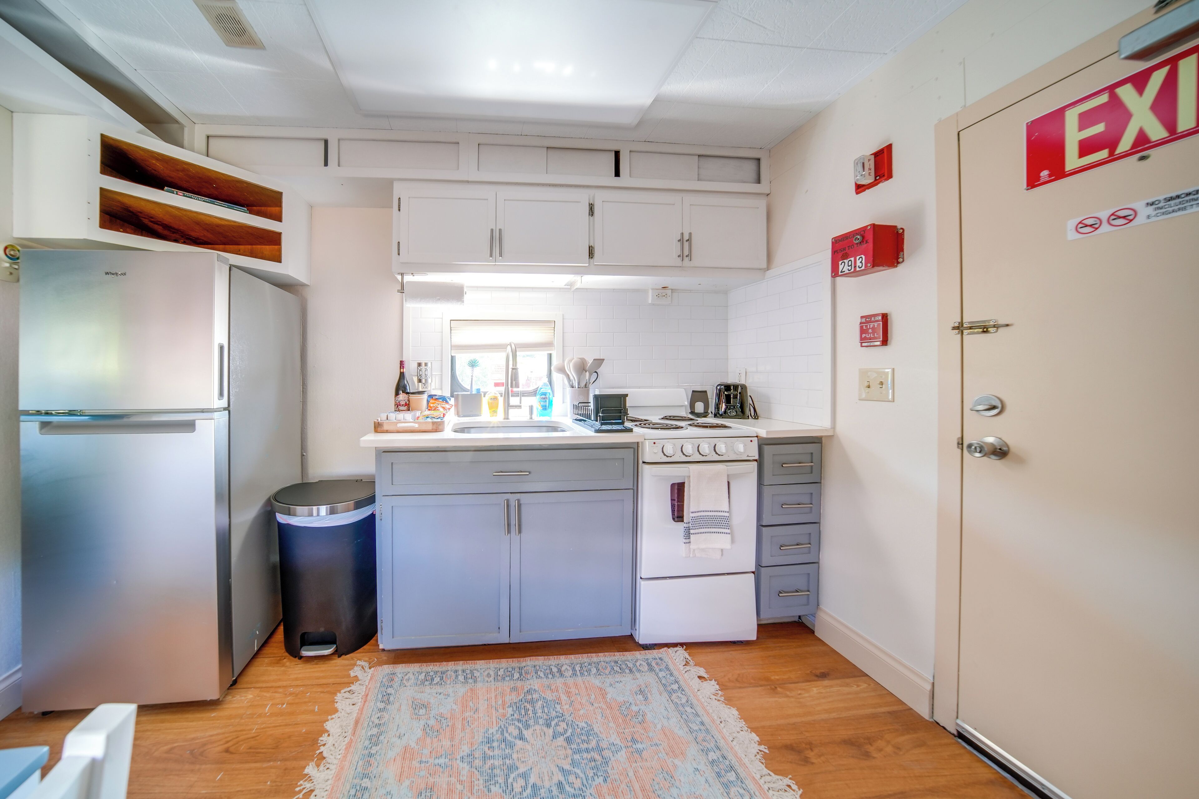 A compact kitchen with a refrigerator, stove, sink, and cabinets.