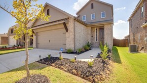 A two-story residential house with a garage, a well-maintained lawn, and a small tree in the front yard. - Yard & Office: Spacious Family Home in Forney (Forney)
