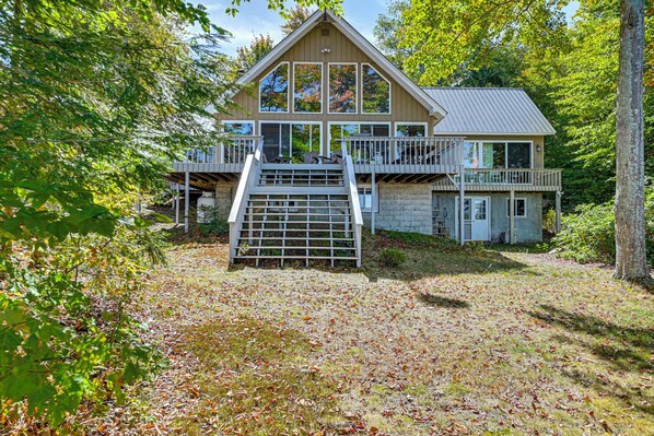 Une cabane à deux étages dotée d’un balcon, d’un escalier et d’une terrasse.