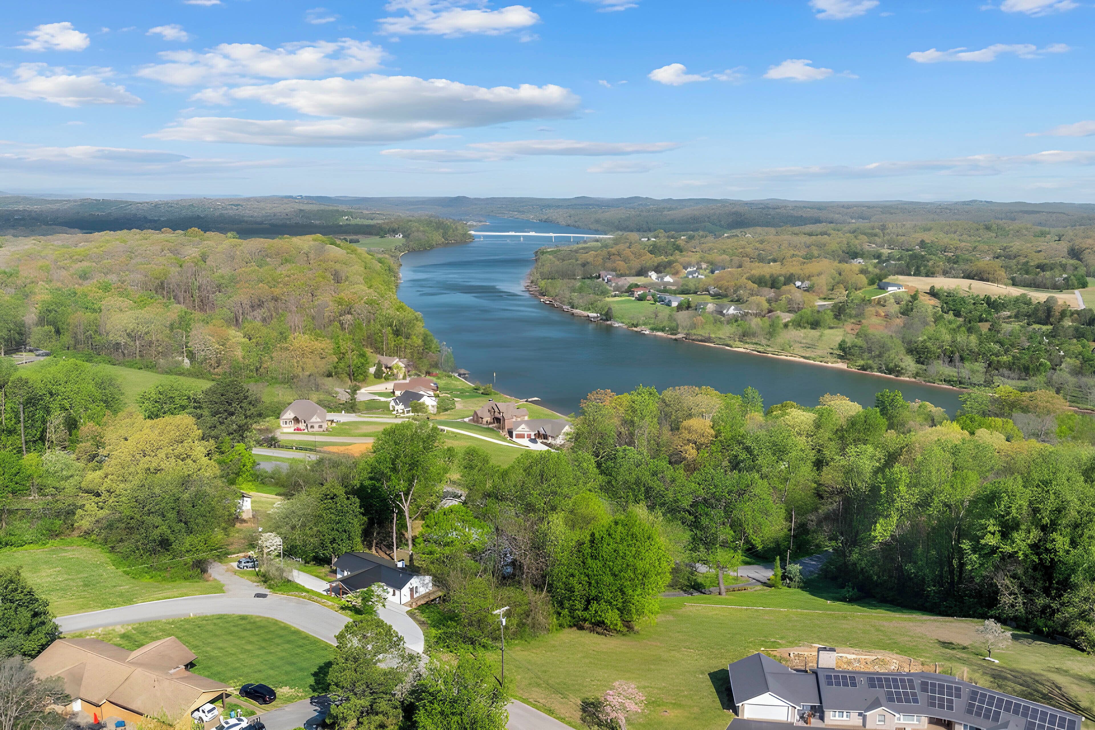 A residential area with houses, a river, and a bridge.