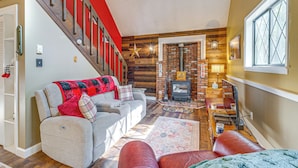 A cozy living room with a fireplace, a staircase, and a window. - Featured on Hgtv! Visit This Lottery Dream Home! (Pocono Lake)