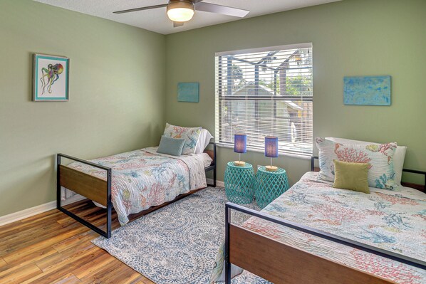 A bedroom with two beds, a wooden floor, and a window with blinds. - Walk to Beach! Palm Coast Oasis w/ Pool (Palm Coast)