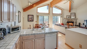 A spacious kitchen with a large island, wooden beams, and a stone fireplace. - < 1 Mi to Diamond Peak: Townhome w/ Lake Views (Incline Village)