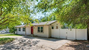 A single-story house with a red door, beige siding, and a white fence. - Walk to Campus, FSU Photo Wall: Inviting Retreat! (Tallahassee)