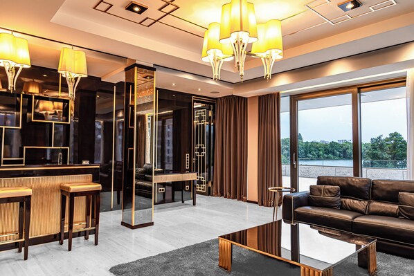A modern living room with a sofa, coffee table, and bar area with stools.