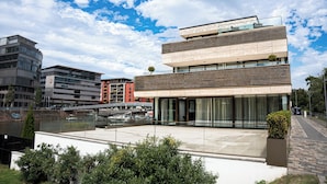 A modern building with a glass facade, a flat roof, and a courtyard. - Main Suites (Frankfurt)