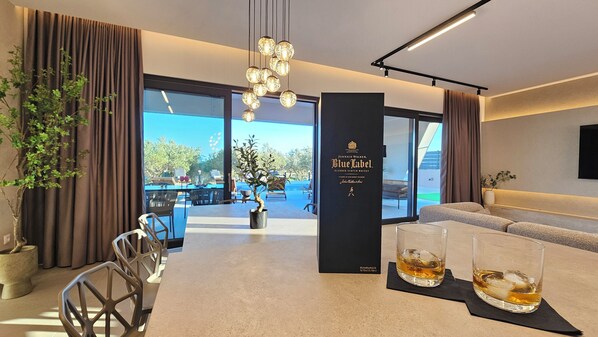 A modern hotel lobby with a seating area, a reception desk, and a large window offering a view of the outdoors.