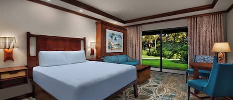 A hotel room with a large bed, a sofa, a desk with a chair, and a view of a garden.