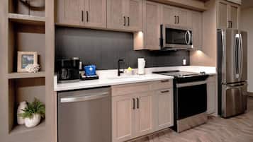 Una cocina moderna con electrodomésticos de acero inoxidable, armarios de madera y un suelo con patrón de espiga.