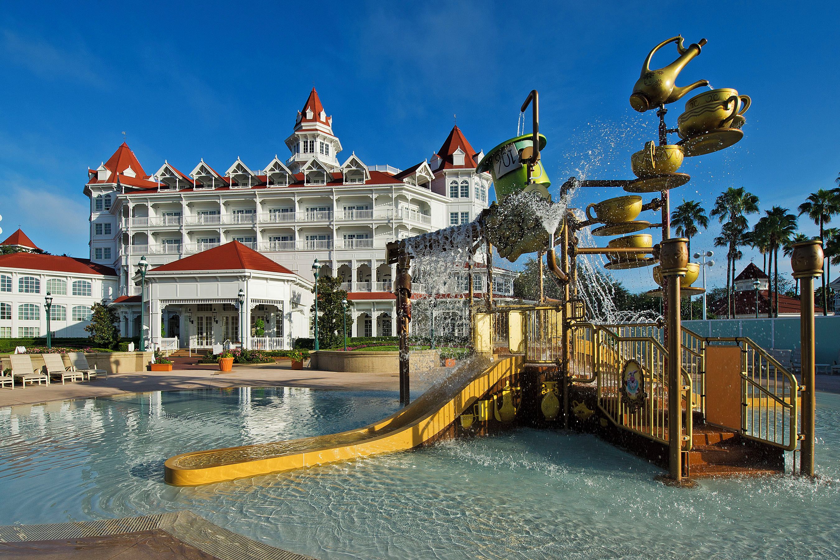 A hotel with a large pool and a water fountain feature.