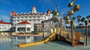 A hotel with a large pool and a water fountain feature.