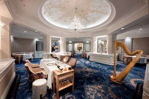A formal dining room with a large chandelier, a harp, and a blue patterned carpet. - The Villas At Disney's Grand Floridian Resort & Spa (Lake Buena Vista)