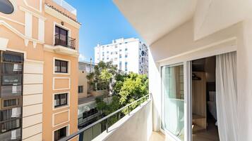 A balcony with a view of neighboring buildings and trees.