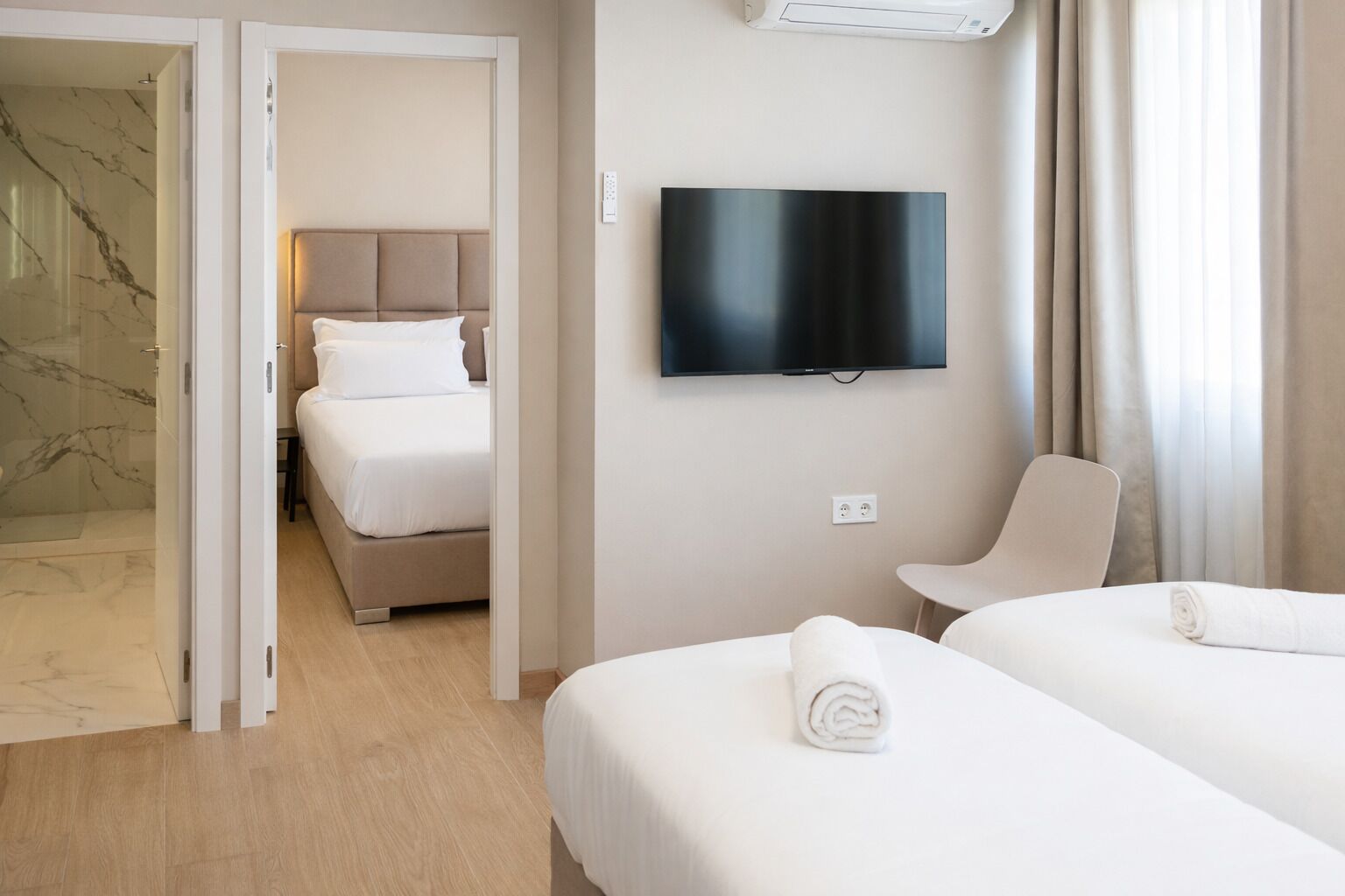 Une chambre d’hôtel équipée d’un lit, d’une télévision, d’une chaise et d’un espace douche.