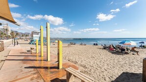 A beach with a wooden boardwalk, beach umbrellas, and people relaxing. - blanca maris (Fuengirola)
