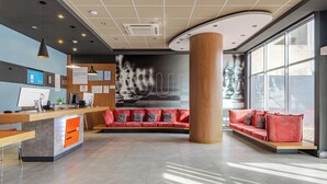 A modern reception area with a desk, computer, and seating area. - Transamerica Fit Aracruz (Aracruz)