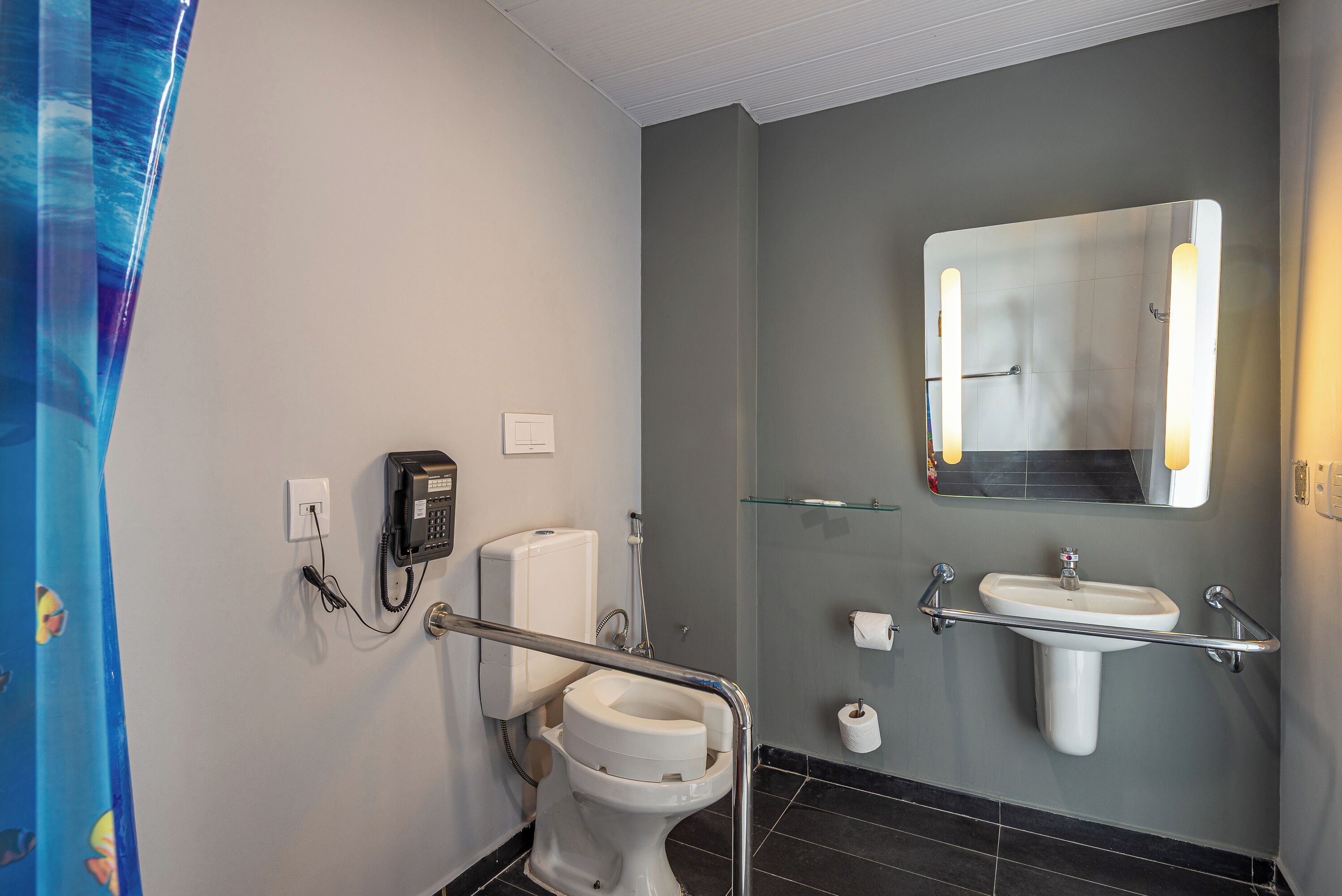 Un baño moderno con inodoro, bidé y lavamanos. Cuenta con una cabina de ducha de vidrio y un espejo con iluminación.
