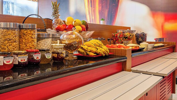 A buffet counter with various food items and condiments, a large decorative glass, and a menu board. - Transamerica Fit Aracruz (Aracruz)