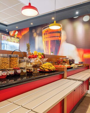 A buffet counter with various food items and condiments, a large decorative glass, and a menu board. - Transamerica Fit Aracruz (Aracruz)