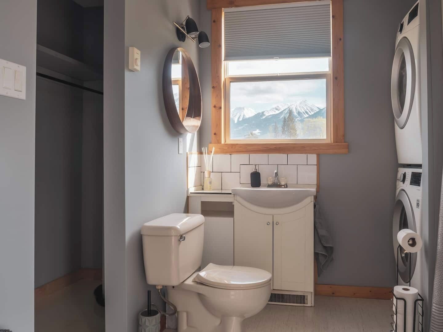 A modern bathroom with a toilet, sink, and washing machine.