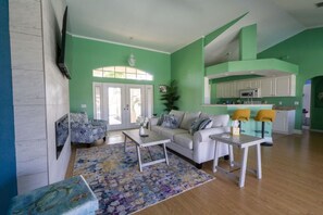 A living room with a sofa, coffee table, and patterned rug. - Island Time (Cape Coral)