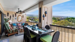 Uma varanda com mesa, cadeiras e vista para a paisagem urbana.