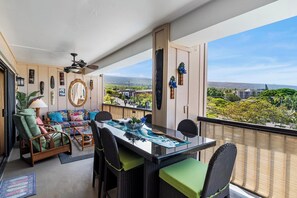 Ein Balkon mit Esstisch, Stühlen und Blick auf eine Stadtansicht.