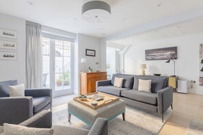 A modern living room with a grey sofa set, a coffee table, and a wooden cabinet.