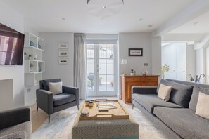 A modern living room with two sofas, a coffee table, and a wooden cabinet.