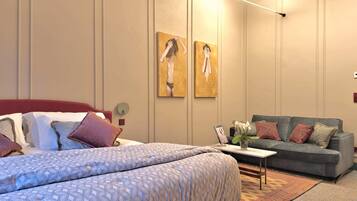 Une chambre à coucher avec un lit, un canapé et deux tableaux accrochés au mur.
