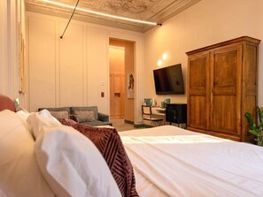 Une chambre à coucher avec un lit, un téléviseur fixé au mur et une armoire en bois.