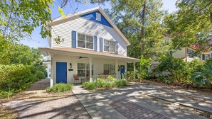 A two-story house with a front porch, a covered entryway, and a small front yard with plants. - 322 S. 5th Street Unit A 3 Bedroom Townhouse (Fernandina Beach)