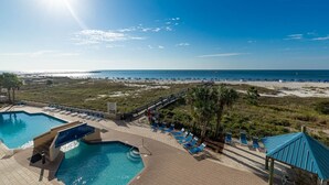 A pool area with multiple pools, sun loungers, and a beach view. - Phoenix East 203 2 Bedroom Condo (Orange Beach)