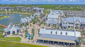 Un complejo turístico con un lago, varias edificaciones y zonas de estar al aire libre.