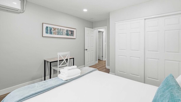 A bedroom with a bed, a desk, a chair, and a door leading to another room. - Chic Modern Stay w Patio Near LA Best Sights6 (Altadena)